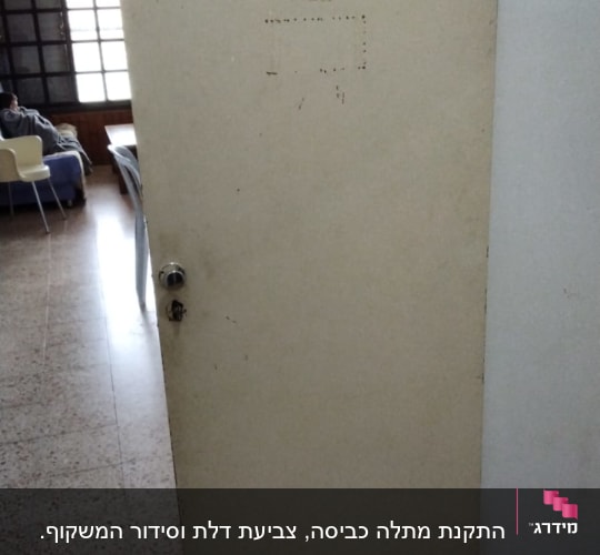 דלת עץ עם ידית מתכת וחור מנעול